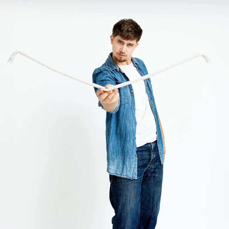 Rubén Silva mostrando una cuerda en una fotografía de estudio